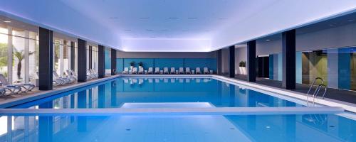 a swimming pool with blue water in a building at Park Plaza Belvedere Medulin in Medulin