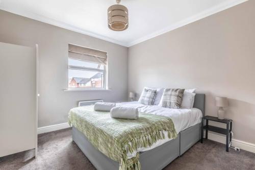 a white bedroom with a bed and a window at Cosy Central Windsor Apartment , Parking in Windsor