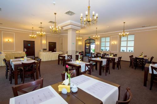 een eetkamer met tafels en stoelen en kroonluchters bij Hotel Residence in Rewal