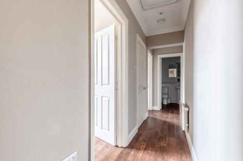 a hallway with white walls and a mirror at Cosy Central Windsor Apartment , Parking in Windsor