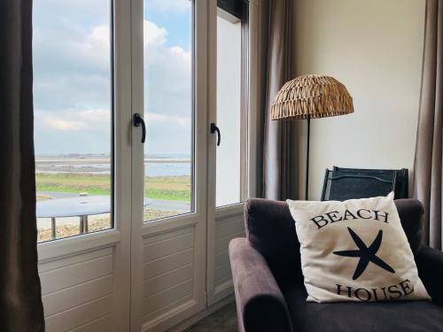 a living room with a chair and a window at Beach House 50 in Omonville-la-Rogue