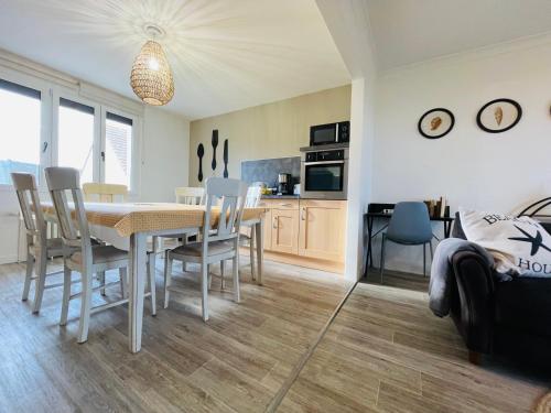 a kitchen and dining room with a table and chairs at Beach House 50 in Omonville-la-Rogue