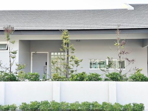 una cerca blanca frente a una casa en Pool Villa by Clickme Home, en Ban Mae Hom