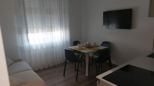 ein Esszimmer mit einem Tisch, Stühlen und einem TV in der Unterkunft Welcome Appartamenti in Matera