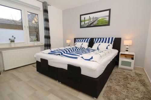 a bedroom with a large bed with blue and white pillows at Watthaus-2 in Rantum
