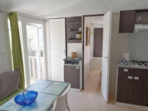 une petite cuisine avec une table dans une pièce dans l'établissement Mobil home Chez 118 Alain, à La Roque-dʼAnthéron