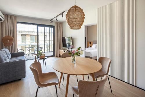 a living room with a table and chairs at Apartamenty na Półwyspie Wydma&Las in Jastarnia