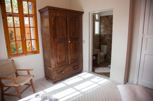 a room with a large wooden cabinet and a bathroom at Villa Terrestre in Lakithra