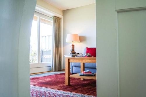 a room with a table with a lamp and a window at Wattkoje-Ein-Appartement-der-besonderen-Art-erwartet-Sie-am-Rande-der-Braderuper-Heide in Braderup