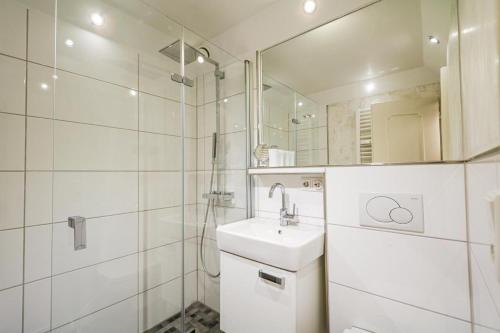 a white bathroom with a sink and a mirror at Wattkoje-Ein-Appartement-der-besonderen-Art-erwartet-Sie-am-Rande-der-Braderuper-Heide in Braderup