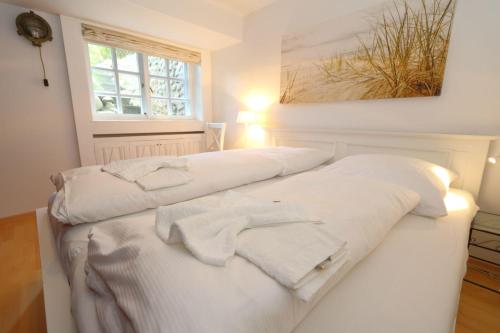 two beds in a room with white towels on them at Wattkoje-Ein-Appartement-der-besonderen-Art-erwartet-Sie-am-Rande-der-Braderuper-Heide in Braderup