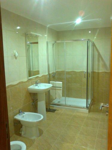 a bathroom with a toilet and a sink and a shower at Casa da Mineira T1 in Geres