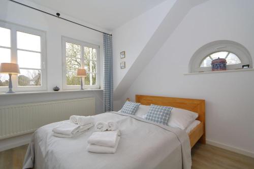 1 dormitorio con 1 cama con toallas en Ferienhaus-Wattpieper, en Munkmarsch