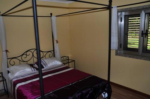 ein Schlafzimmer mit Himmelbett und Fenster in der Unterkunft Casa da Mineira T1 in Geres