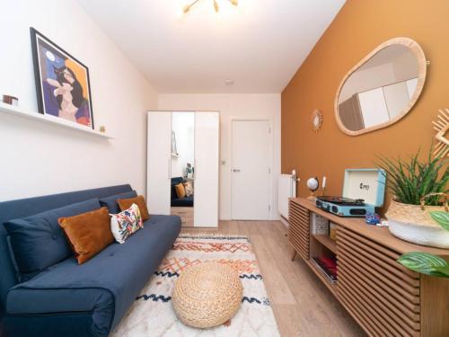 a living room with a blue couch and a mirror at Pass the Keys Stunning and Stylish Flat Mins From Central London in London