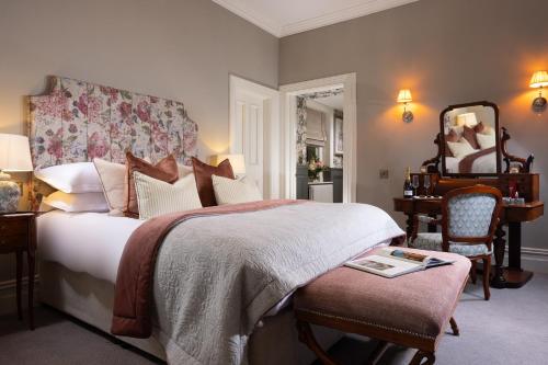 a bedroom with a bed and a chair and a mirror at Killashee Hotel in Naas