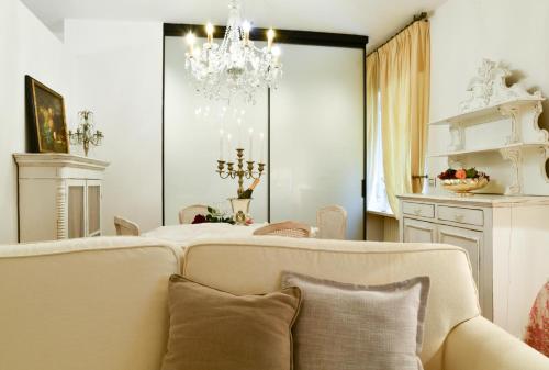 - un salon avec un canapé et un lustre dans l'établissement Emily Luxury Apartment, à Vérone