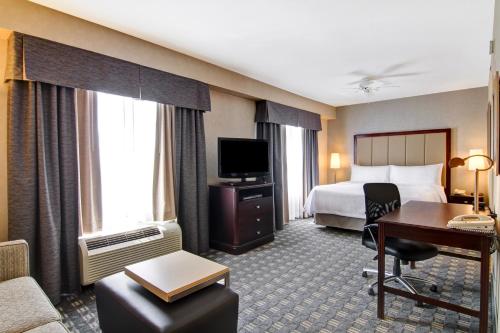 a hotel room with a bed and a desk at Homewood Suites by Hilton Toronto-Oakville in Oakville