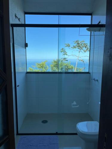 a bathroom with a shower and a toilet and a window at CASA DE TUCA in Ilhabela