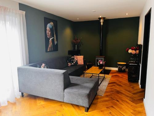 uma sala de estar com um sofá cinzento e um quadro em Casa Clementine - Boutique Guesthouse em Veldhoven