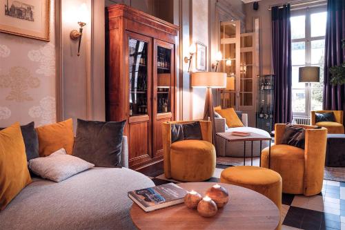 a living room with a couch and chairs and a table at Domaine de Joinville in Eu