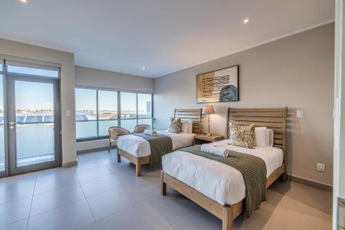 a bedroom with two beds and a balcony at Seafront Condo at The Pier 25 in Swakopmund