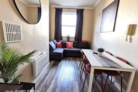 a living room with a couch and a table with chairs at Cosy Apartment near OConnell ST RELIABLE FAST WIFI in Dublin
