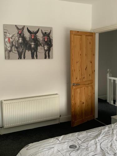 ein Schlafzimmer mit einem Gemälde von Pferden an der Wand in der Unterkunft Beautiful house Perfect Location Lytham St Annes in Saint Annes on the Sea