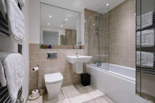 een badkamer met een toilet, een wastafel en een bad bij Very Modern 17min London Paddington, 8min legoland in Slough