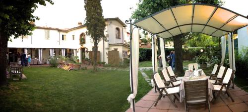 a patio area with chairs, tables and umbrellas at La Bussola Da Gino in Quarrata