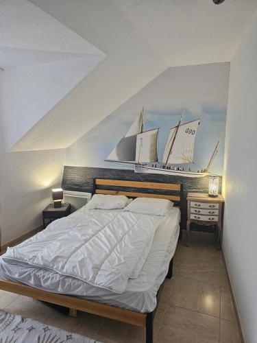una camera da letto con un grande letto con vele appese al muro di Saint Martin Appartement Duplex Proximité Immédiate Mer & Commerces a Bréhal