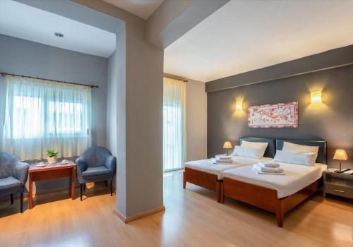 ein Hotelzimmer mit einem Bett und zwei Stühlen in der Unterkunft Ampelia Hotel Kassandra in Chaniotis