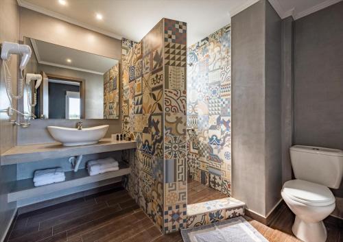 ein Bad mit einem Waschbecken und einem WC in der Unterkunft Ampelia Hotel Kassandra in Chaniotis