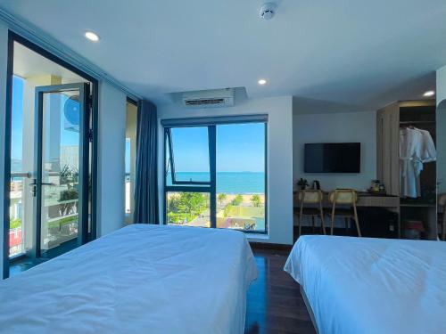 a bedroom with two beds and a view of the ocean at JOYCE HOUSE in Quy Nhon