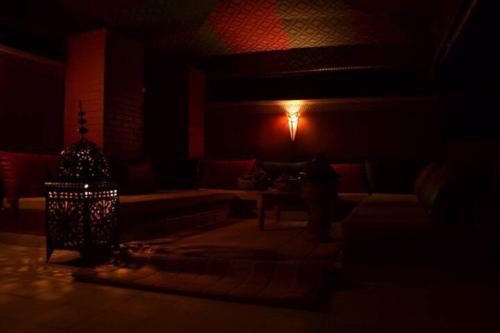 Habitación oscura con sofá y luz en Chez Zohra, en Taroudant