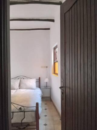 een slaapkamer met een bed en een houten deur bij Chez Zohra in Taroudant