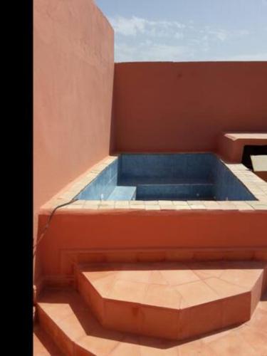 a swimming pool in a building with a blue tub at Chez Zohra in Taroudant