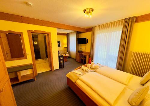 Habitación de hotel con cama grande y baño. en Hotel Restaurant Adler Stube, en Münstertal