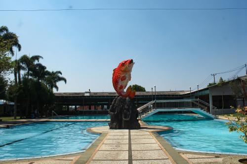 a statue of a fish on a fountain next to a pool at Nirwana Lembang in Tangkubanperahu
