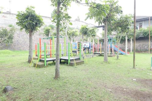 a park with a colorful playground with trees in it at Nirwana Lembang in Tangkubanperahu