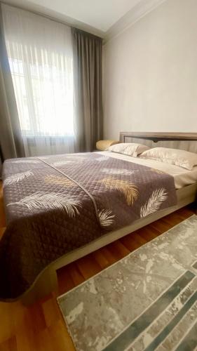 a large bed in a bedroom with a window at 2х комнатная квартира на Айтиева in Taraz