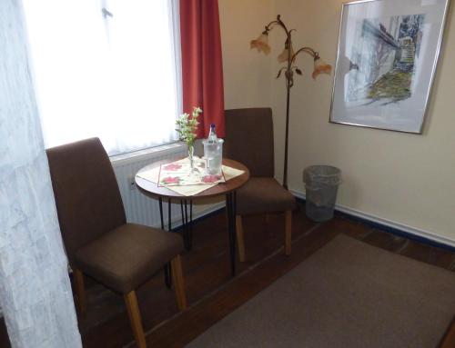 a small table and chairs in a room with a window at Gasthof & Fleischerei Endler in Rheinsberg