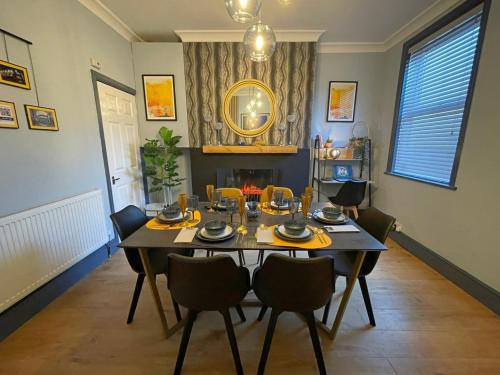 a dining room with a table with chairs and a mirror at Arena House - Sleeps 6 in Sheffield