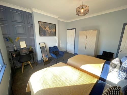 謝菲爾德的住宿－Arena House - Sleeps 6，一间卧室配有两张床、一张桌子和一把椅子