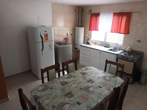 a kitchen with a table and a kitchen with a refrigerator at Lo de fernando 3 in Río Gallegos