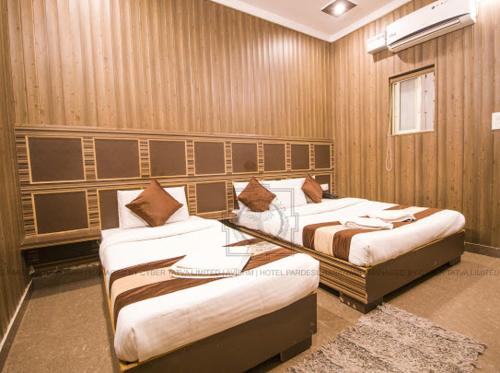 Habitación con 2 camas en una habitación en Hotel Paradesi and Restaurant AJ Group en Haridwār
