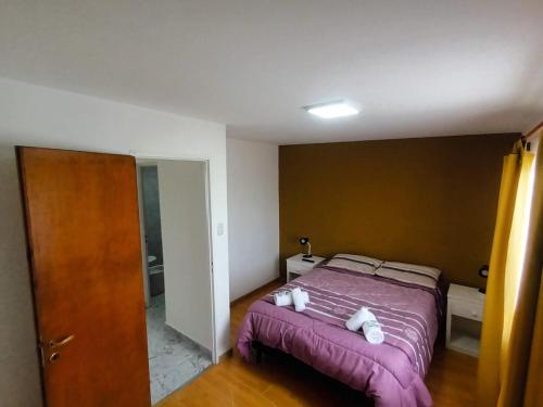 um quarto com uma cama roxa com dois ursinhos de peluche em Lo de fernando 3 em Río Gallegos