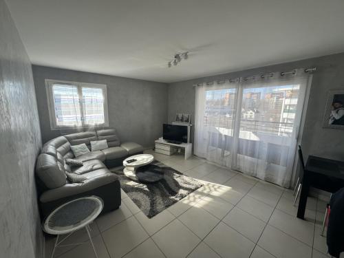 ein Wohnzimmer mit einer Couch und einem Tisch in der Unterkunft Appartement de Romain in Annecy
