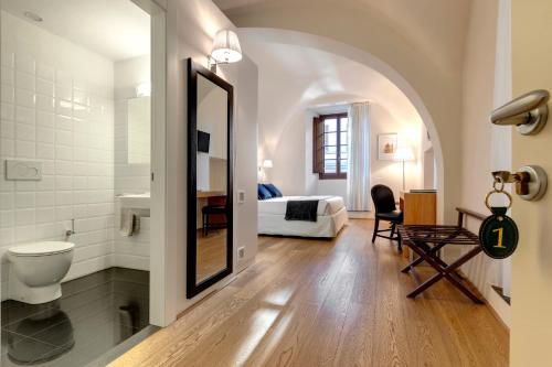 a bathroom with a toilet and a bedroom with a bed at B&B Dell'Olio in Florence