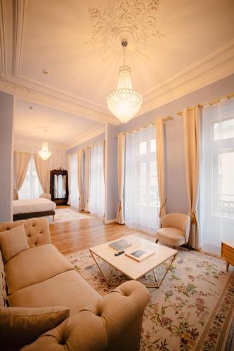 a living room with a couch and a table at Grand Hôtel de l'Europe - Morlaix Centre in Morlaix